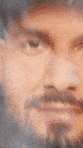 a close up of a man 's face with a beard and a hat