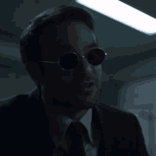 a man in a suit and tie wearing sunglasses