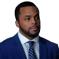 a man in a blue suit and tie looks to the side