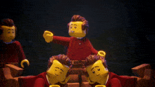 a group of lego figures in red shirts are laying on the ground