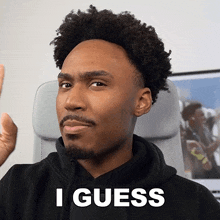 a man in a black hoodie says i guess in white letters