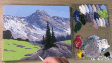 a person is painting a mountain landscape with a palette next to it that says made in animotica