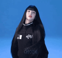 a woman with very long black hair is wearing a black choom jacket