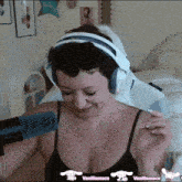 a woman wearing headphones and a black tank top with the words vanillamace on the bottom
