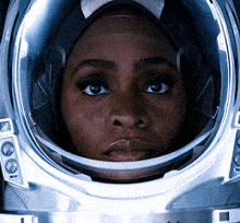 a close up of a woman 's face in a space suit