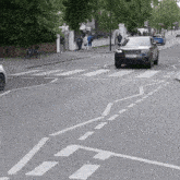 a black car with a license plate that says ec13 bnm is driving down a street