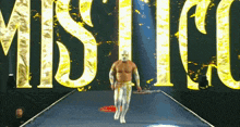 a wrestler is walking down a ramp with the word mistico in the background