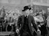 a black and white photo of a man in a suit and hat