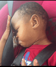 a baby sleeping in a car seat with a warning on the back
