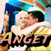 a man kissing a woman on the cheek in front of a sign that says ' anget '
