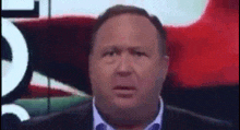 a man in a suit and tie is making a funny face in front of a red background
