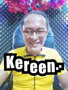 a man wearing glasses and a yellow shirt with the name kereen-