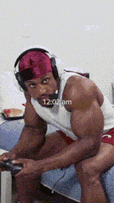 a man wearing headphones is playing a video game with the time of 12:02 am