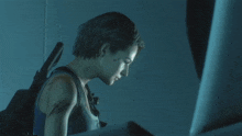 a woman in a blue tank top is holding a gun behind her back