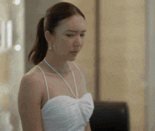 a woman in a white dress with a ponytail