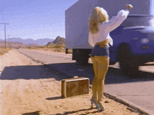 a woman standing on the side of the road with a briefcase