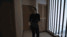 a woman is standing in a hallway with the words made in animatica on the bottom right