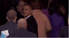 a man in a suit and tie says " i want to take a look one more time " in front of a crowd