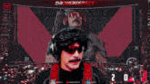 a man wearing sunglasses and headphones is holding a camera in front of a screen with dr disrespect written on it