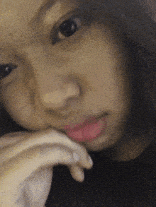 a close up of a woman 's face with a hand on her chin