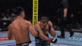 two men are fighting in a boxing ring and one of them is wearing a venum belt