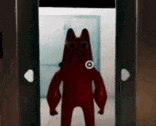 a red jelly bean is standing in a doorway .