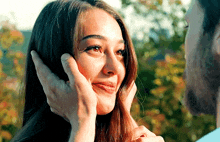 a man is touching a woman 's face and smiling