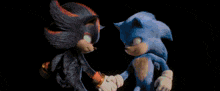 two sonic the hedgehogs shaking hands in front of a light beam .