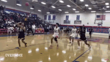 a basketball game is being played in a gym with the word overtime on the bottom right