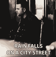 rain falls on a city street playing guitar strumming singing david nail