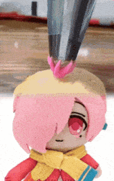 a stuffed doll with pink hair and red eyes is being decorated