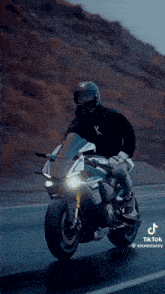 a man is riding a motorcycle on a road .