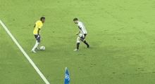 a referee is standing on a soccer field with two soccer players and a flag .