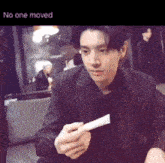 a man in a suit is holding a piece of paper with the words " no one moved " underneath him