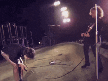a man kneeling down on a stage with a microphone in front of him