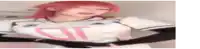a blurry picture of a woman with red hair wearing a white shirt with a pink letter d on it .