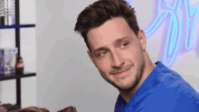 a man in a blue scrub is looking at a dog