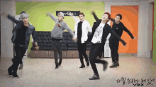 a group of young men are dancing in front of a sign that says vixx on it