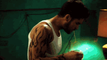 a man with a tattoo on his arm is holding a glass