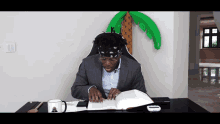 a man sits at a desk reading a book