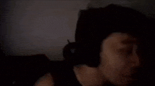 a woman is sitting in a dark room with her eyes closed .