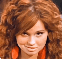 a close up of a woman 's face with a red shirt on