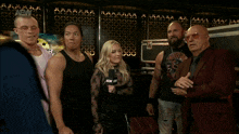 a group of people are standing in front of a wall that says aew on it