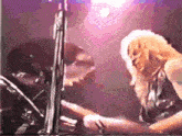 a woman is playing drums in front of a microphone