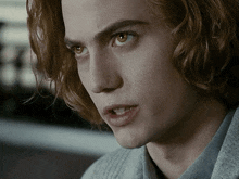 a close up of a man 's face with a gray sweater on