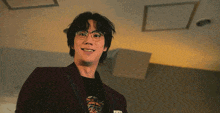 a man wearing glasses and a red jacket smiles