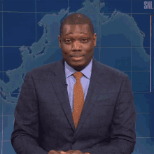 a man in a suit and tie is standing in front of a snl logo