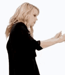 the woman is wearing a black dress and a black jacket .