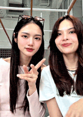 two women are standing next to each other and one is wearing sunglasses
