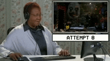 a woman wearing headphones is sitting in front of a computer screen that says attempt 8 on it